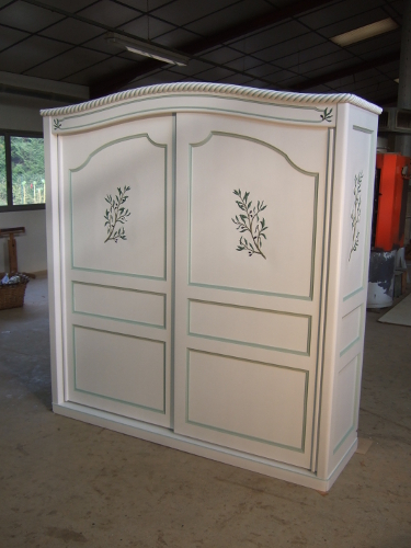 armoire blanche avec des liserets verts aux portes coulissantes