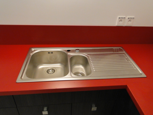 evier inox sur un dessus de cuisine rouge