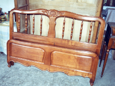 lit louis XV à balustres et pieds sculptés en volute ayant un petit dossier bas